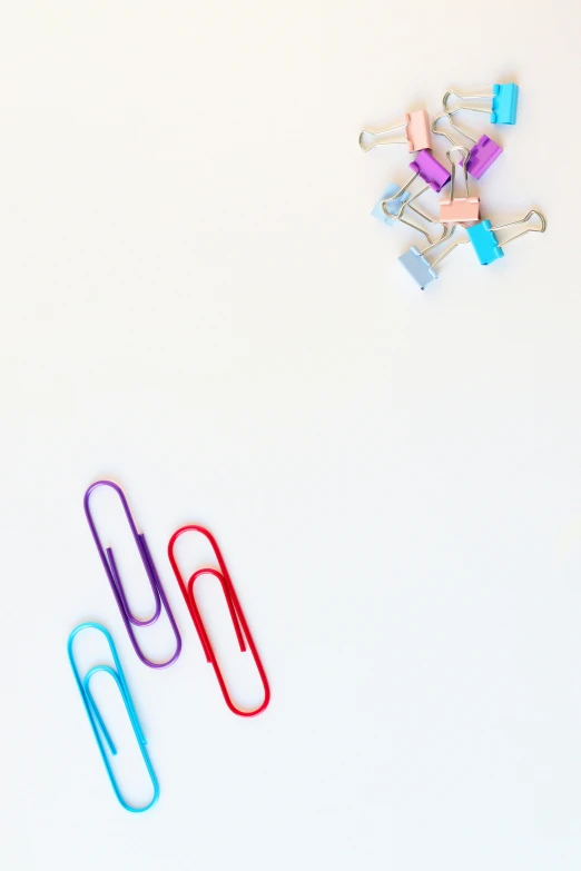 a bunch of paper clips sitting on top of a white surface, by Nicolette Macnamara, pexels, blue and purple, keys, red and cyan ink, floating objects