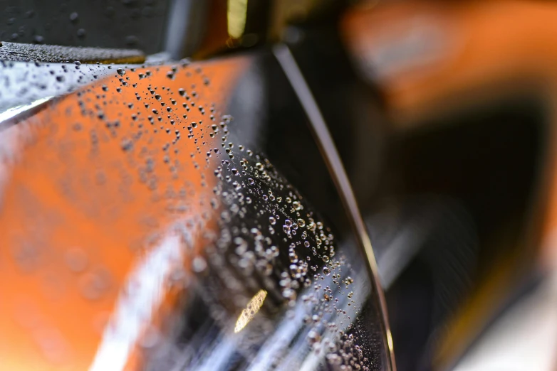 a close up of the side mirror of a motorcycle, a stipple, pexels contest winner, process art, spraying liquid, orange details, thumbnail, highly polished