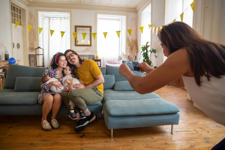 a group of people sitting on top of a blue couch, a picture, pexels contest winner, happening, portrait of family of three, instax, yellow theme, decoration