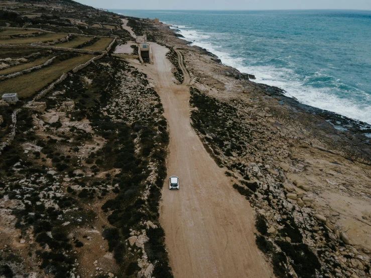 a car driving down a dirt road next to the ocean, les nabis, flat lay, rocky coast, high quality image”, multiple stories