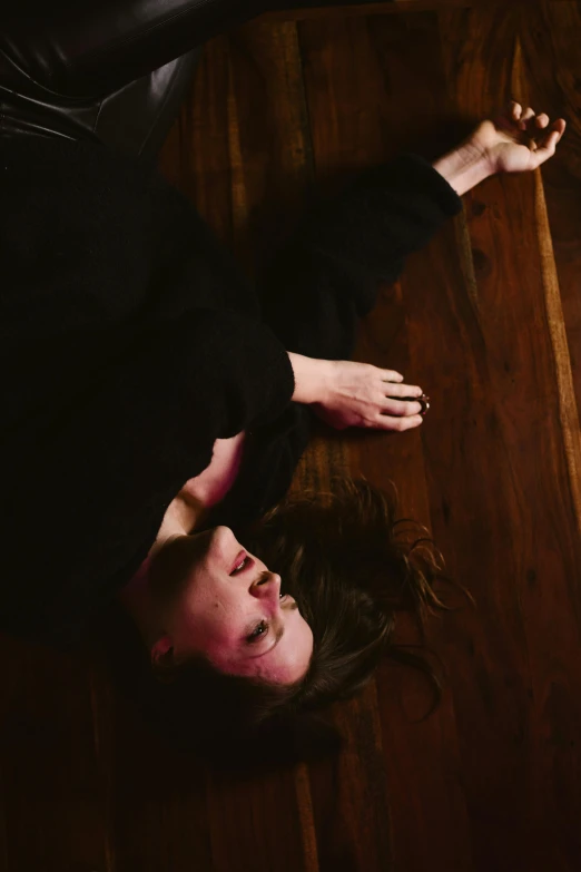a woman laying on top of a wooden floor, by Grace Polit, unsplash, renaissance, captures emotion and movement, video still, distraught, taken in the late 2010s