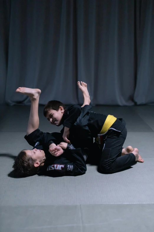 a couple of people laying on top of a floor, martial arts, kids, ouchh and and innate studio, jaime jasso