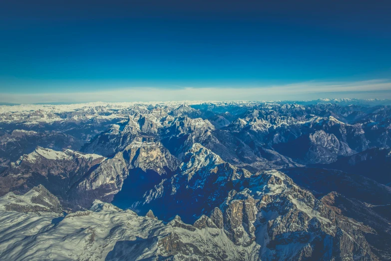 a view of the mountains from an airplane, an album cover, pexels contest winner, baroque, cold, blue, multiple stories, 1 2 9 7