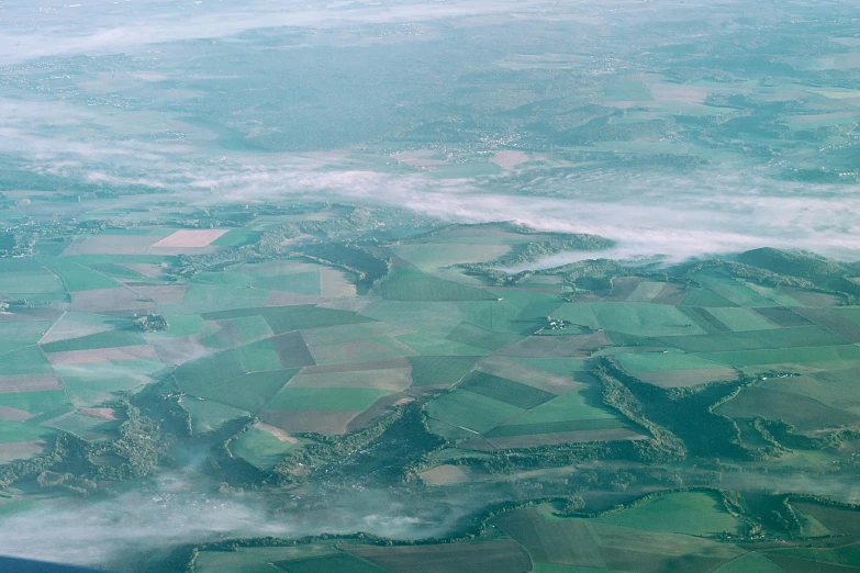 a view of the countryside from an airplane, by Adam Marczyński, pexels contest winner, figuration libre, light green mist, patchwork, taken in 2022, slide show