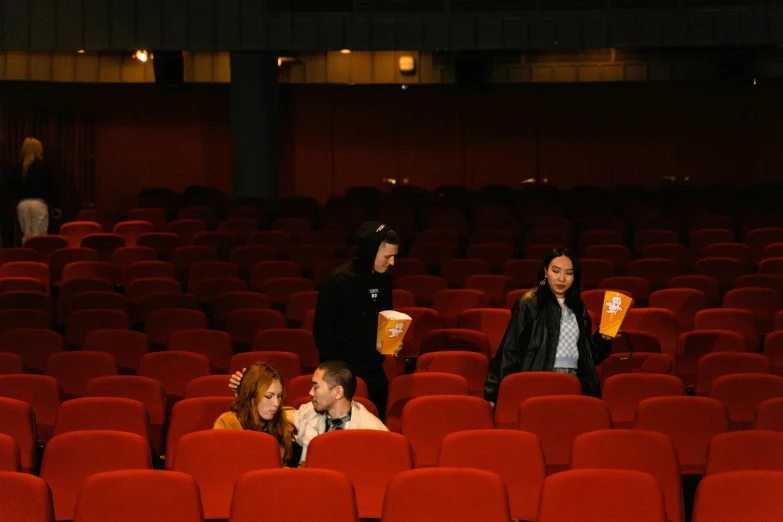 a group of people standing next to each other in a theater, empty stools, shot with sony alpha, square, movies