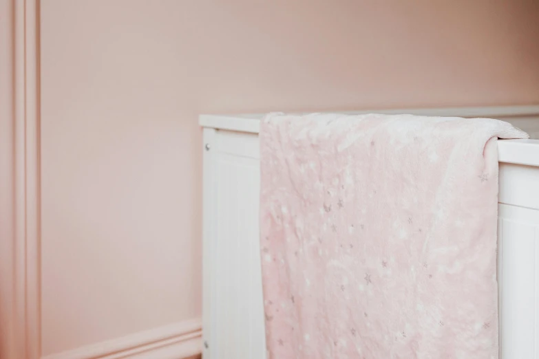 a white crib with a pink blanket on top of it, by Alice Mason, unsplash, light and space, with crystals on the walls, close up shot from the side, starscape, shot on sony a 7 iii