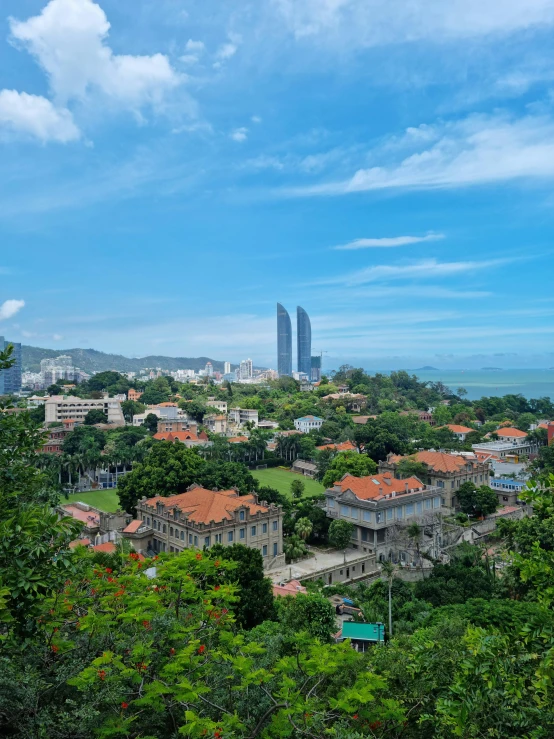 a view of a city from the top of a hill, tropical coastal city, square, shot on iphone 1 3 pro max, 4k image