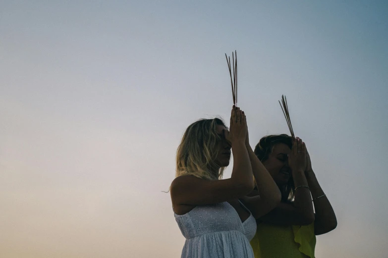 a couple of women standing next to each other, unsplash, sacrificial altar, palm lines, summer evening, profile image