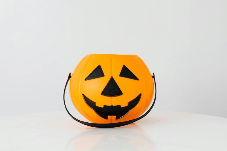 a halloween pumpkin bucket sitting on top of a table, official product photo, front facing camera, medium, brightly lit