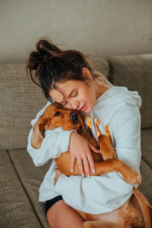 a woman sitting on a couch holding a dog, embrace, profile image, trending photo, brown