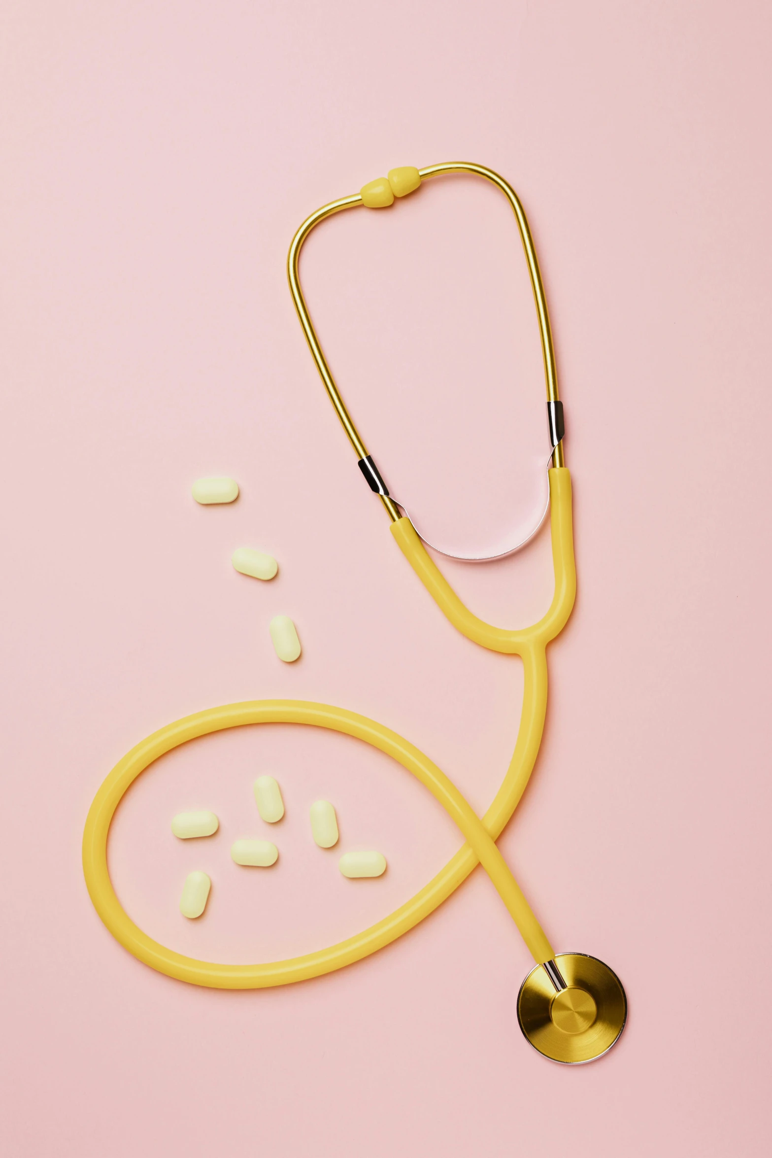 a stethoscope and pills on a pink background, by Carey Morris, yellow aureole, hero shot, schools, vanilla