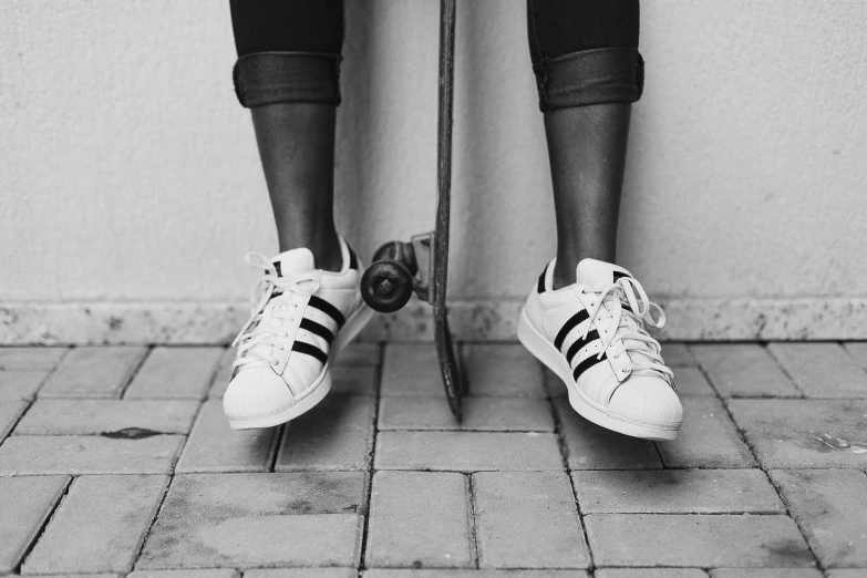 a black and white photo of a person on a skateboard, by Emma Andijewska, unsplash, adidas painting, black female, legs replaced with human legs, photo realistic”