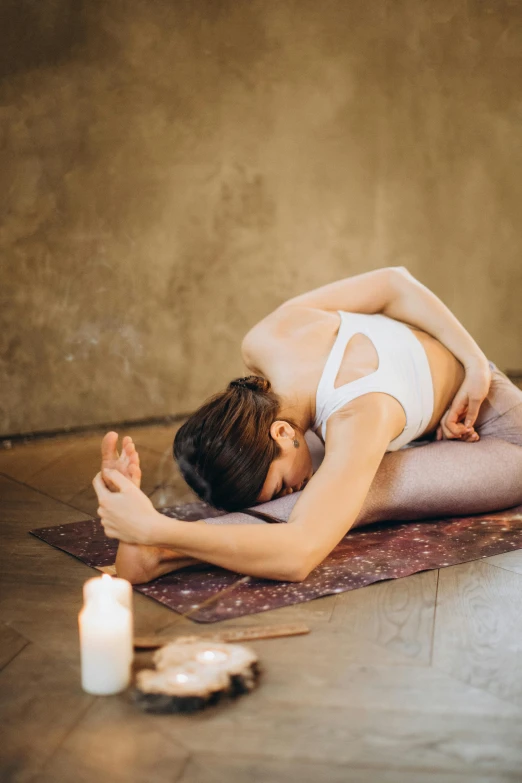 a woman is doing a yoga pose on a rug, by Matija Jama, trending on pexels, renaissance, natural candle lighting, back arched, sweating, multi-part