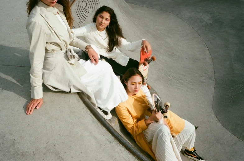a group of women sitting on top of a skateboard ramp, an album cover, inspired by Fei Danxu, trending on unsplash, gutai group, white hanfu, wearing off - white style, at a fashion shoot, 15081959 21121991 01012000 4k