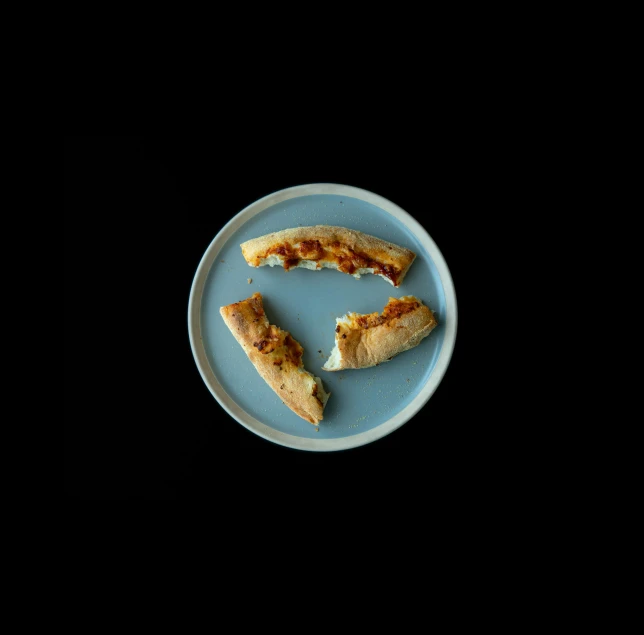 a piece of pizza sitting on top of a blue plate, in front of a black background, thumbnail, ignant, with bread in the slots