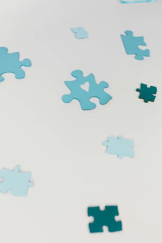 a pile of puzzle pieces sitting on top of a table, pastel blue, medium-shot, stickers, detail shot