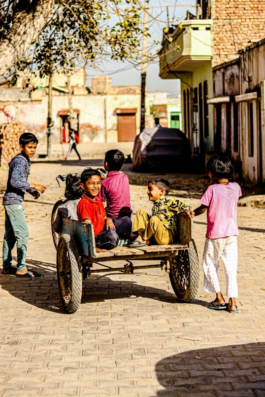 a group of people riding on the back of a horse drawn carriage, by Peter Churcher, pexels contest winner, happening, kids playing, in a village, square, promotional image