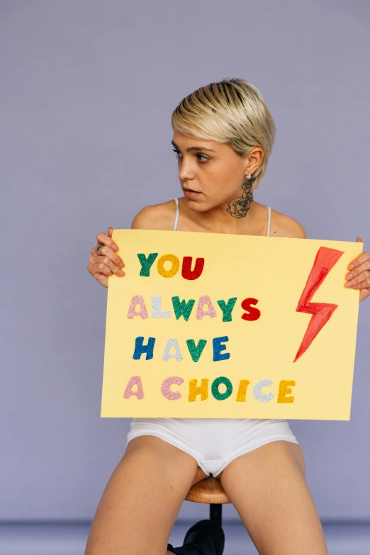 a woman holding a sign that says you always have a choice, a photo, trending on pexels, feminist art, lesbians, lightening, girl with short white hair, promo photo