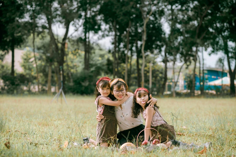 a group of children sitting on top of a lush green field, a picture, by Tan Ting-pho, pexels contest winner, realism, hugging her knees, of a family standing in a park, sisters, three