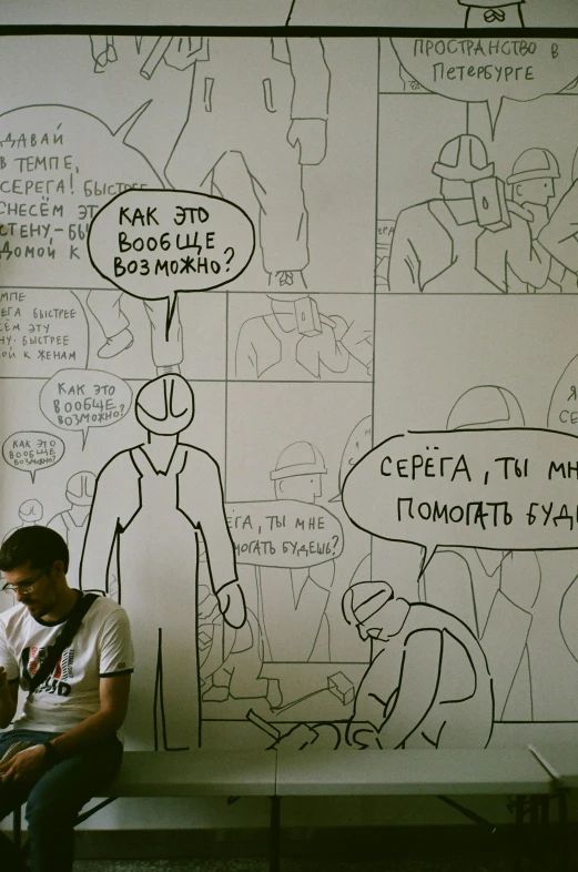 a man sitting on a bench in front of a drawing on a wall, a cartoon, inspired by István Orosz, reddit, 2 5 6 x 2 5 6, moscow metro, comic strip style, closeup!!!!!!