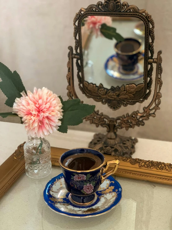 a cup of coffee sitting on a saucer next to a mirror, ottoman miniature style, 🚿🗝📝, 8 k image