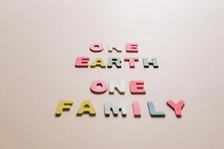 a sign that says one earth one family, pexels, folk art, pastel colored, pink, press shot, material pack