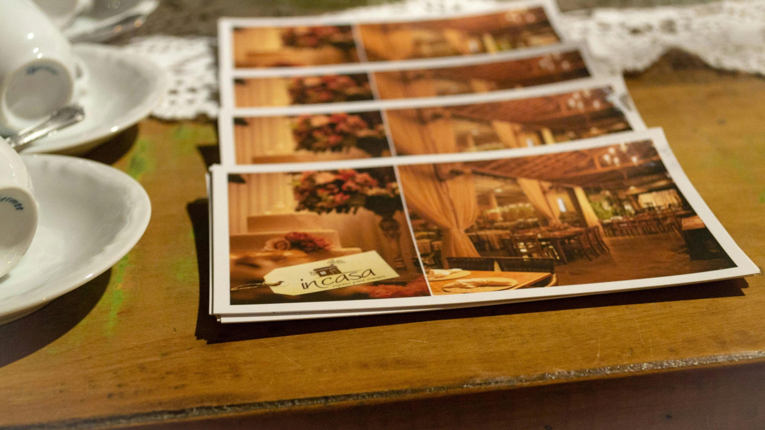 a magazine sitting on top of a wooden table, a picture, cards, restaurant interior photography, foto realista, brown