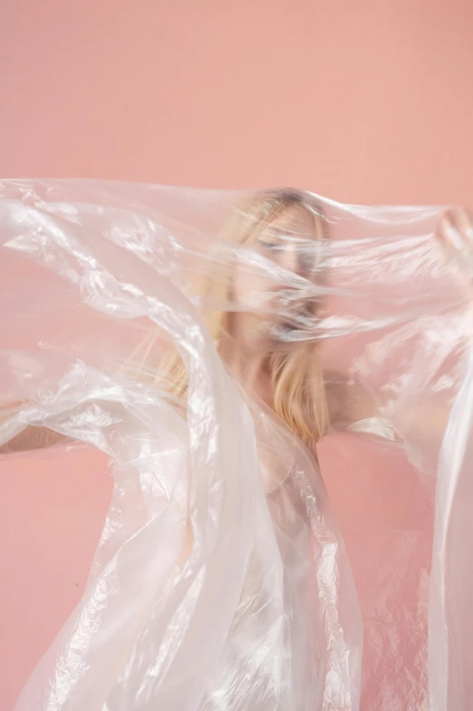 a woman holding a plastic bag over her head, an album cover, by Sara Saftleven, unsplash contest winner, conceptual art, flowing pink-colored silk, translucent white skin, a blond, translucent body