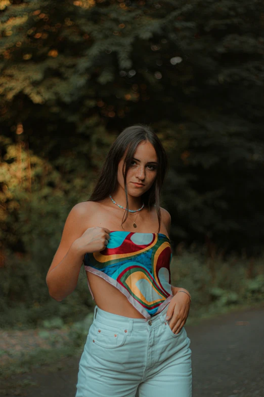 a woman standing in the middle of a road, an album cover, inspired by Elsa Bleda, pexels contest winner, graffiti, is wearing a swimsuit, in front of a forest background, croptop, 🤤 girl portrait