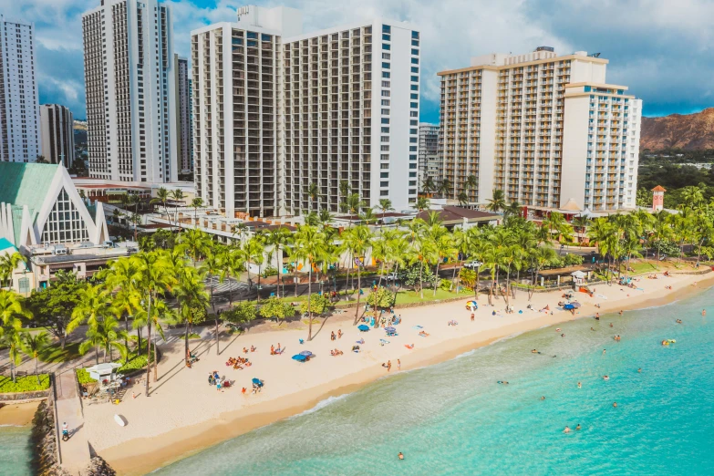 a beach with palm trees and buildings in the background, high rise buildings, aerial, overlooking the ocean