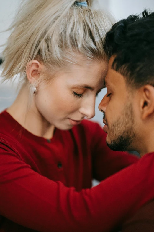 a man and a woman looking at each other, trending on pexels, wearing a red turtleneck sweater, making out, spiky, mixed race