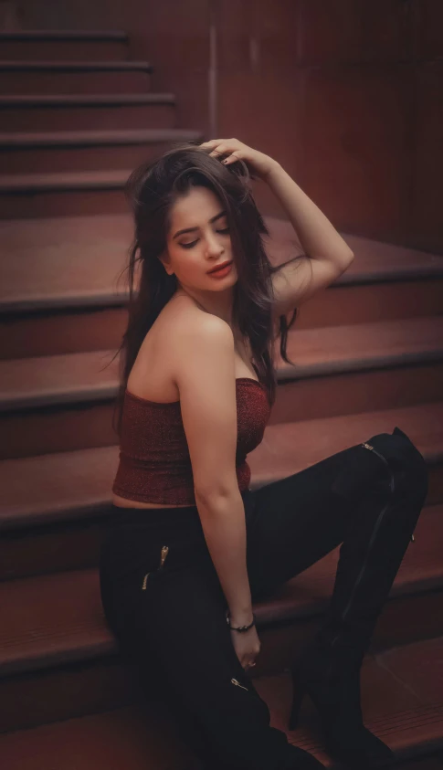 a woman sitting on a set of stairs, by Robbie Trevino, pexels contest winner, tachisme, brown corset, glowing red, indian, casual pose