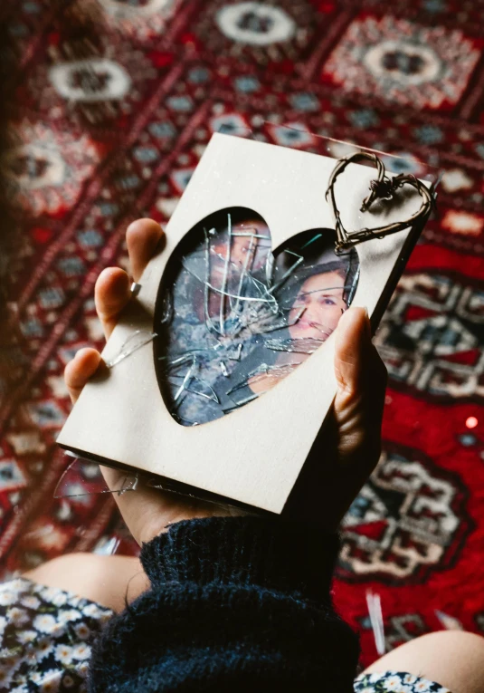 a person holding a picture in a picture frame, by Julia Pishtar, pexels contest winner, auto-destructive art, broken heart, portra 8 0 0 ”, flatlay, full protrait