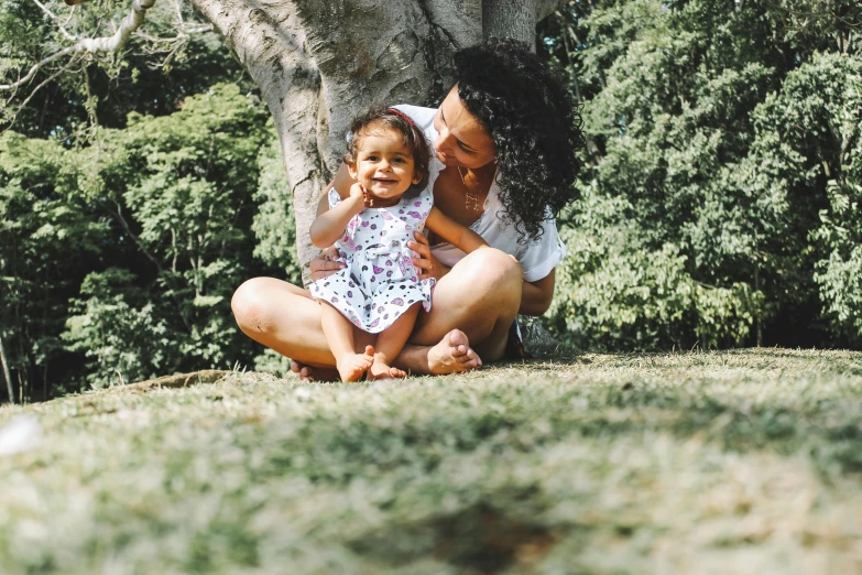 a woman and a child sitting under a tree, pexels contest winner, te pae, 2 years old, avatar image, woman holding another woman