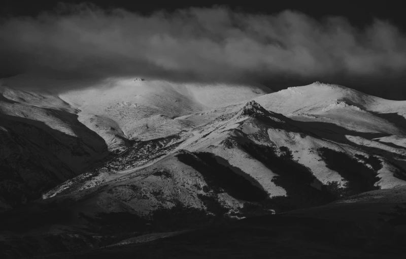 a black and white photo of snow covered mountains, a black and white photo, by Cedric Peyravernay, unsplash contest winner, baroque, somber colors, hills, dark light, kramskoi 4 k