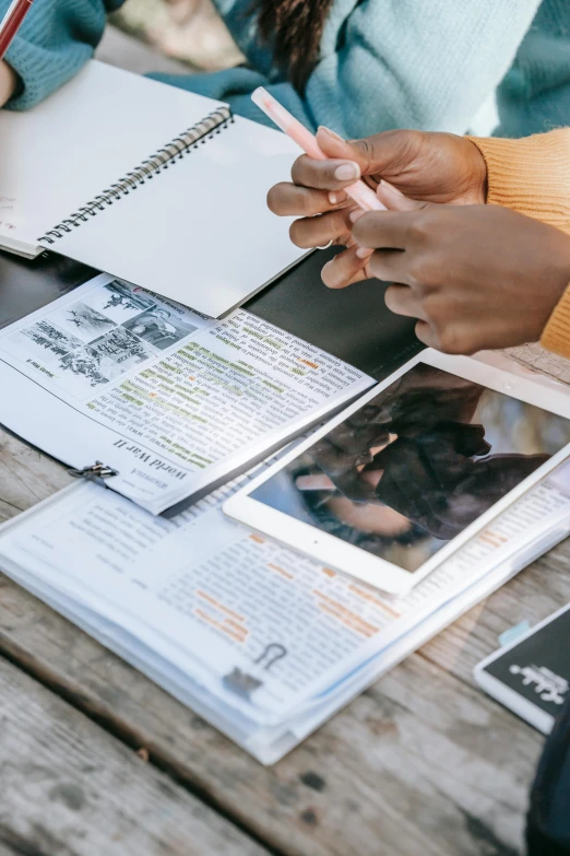 a group of people sitting around a wooden table, a picture, diary on her hand, colour photo, studying, graphic detail