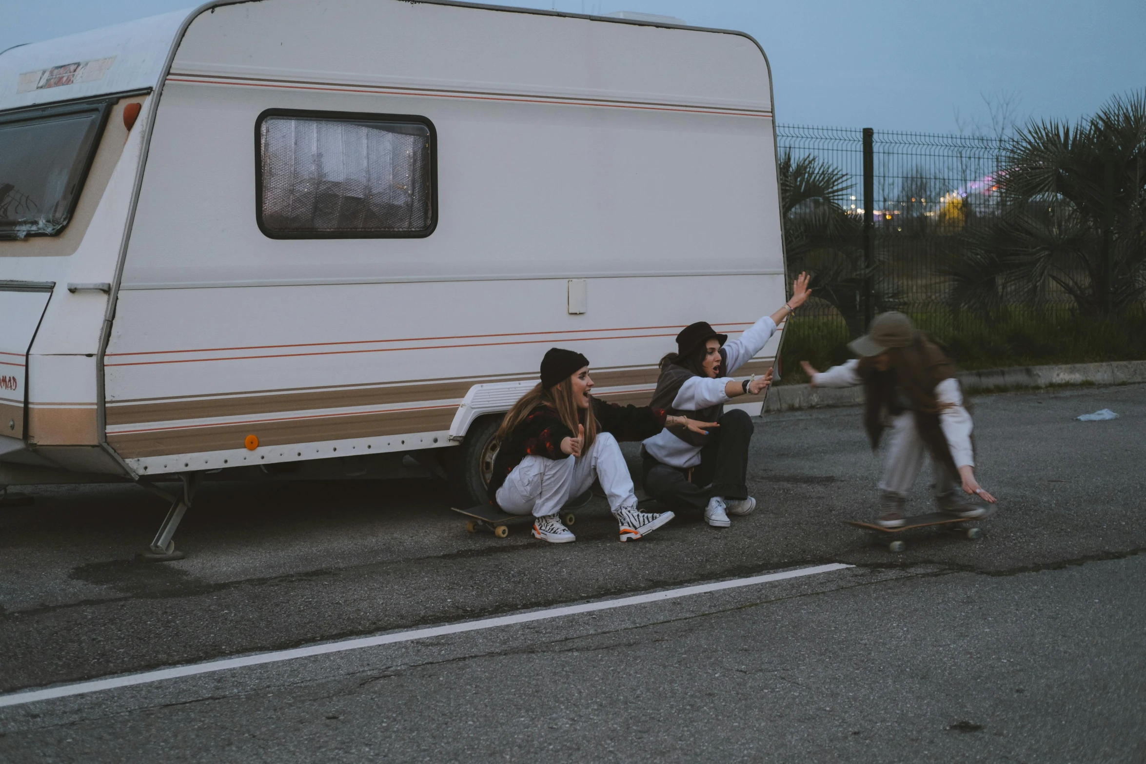 a group of people riding skateboards next to a camper, pexels contest winner, realism, murder scene, playful pose, caravan, on ground