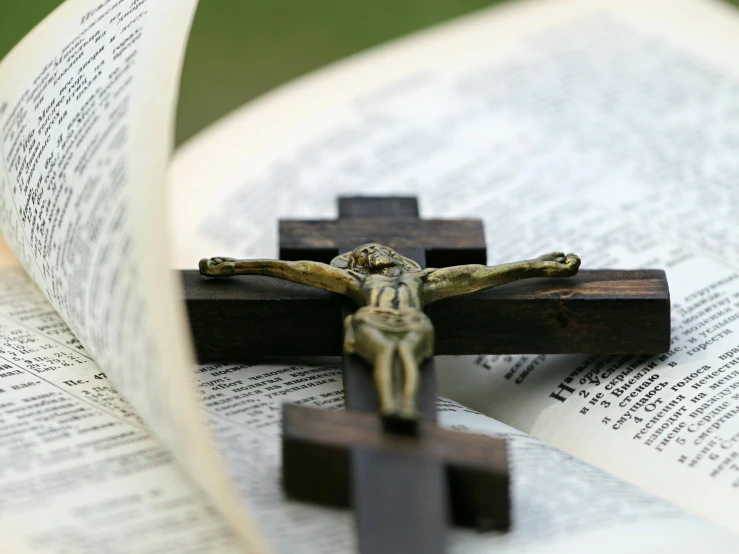 a cross sitting on top of an open book, thumbnail, crucifixion, fan favorite, pontifex