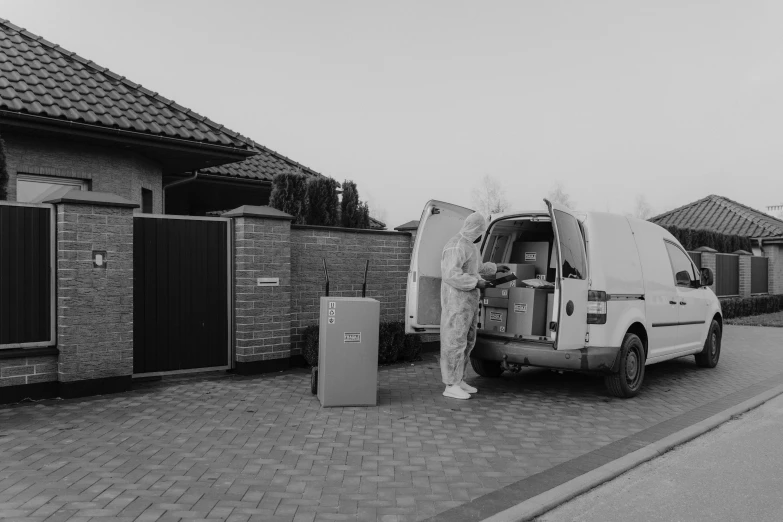 a black and white photo of a van parked in front of a house, by Tobias Stimmer, pexels contest winner, one single man in a hazmat suit, delivering mail, gif, maintenance photo