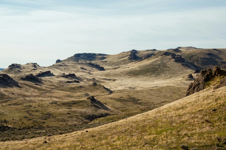 a man riding on the back of a horse down a hill, unsplash, les nabis, landscape of flat wastelands, oregon trail, seen from a distance, west slav features