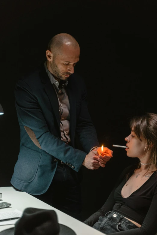 a man lighting a candle on a woman's face, by Adam Marczyński, a magician's chamber, jason statham, profile image, production photo