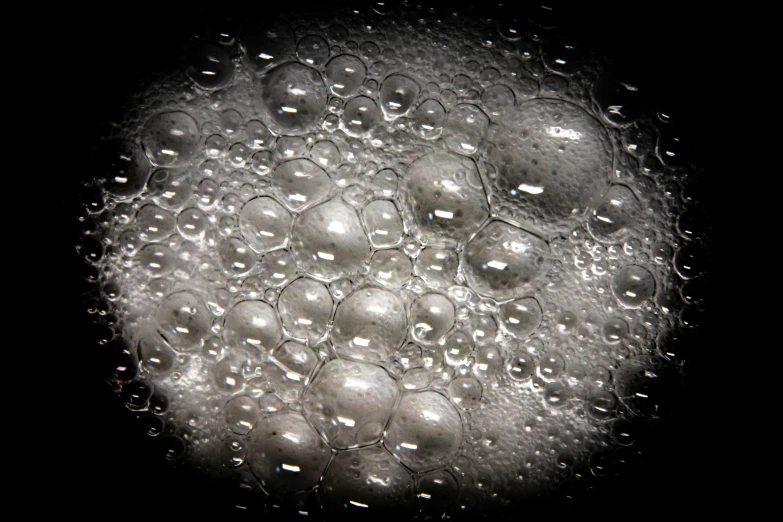 a close up of water bubbles on a black surface, a stipple, flickr, bubble goth makeup, foamy bubbles, transparent goo, bottom - view
