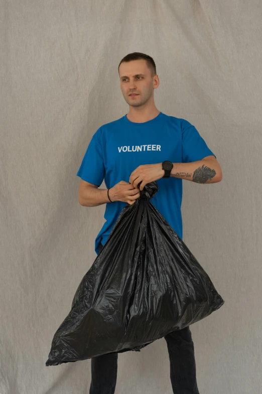 a man in a blue shirt holding a black bag, full of trash, 3 meters, profile image, small