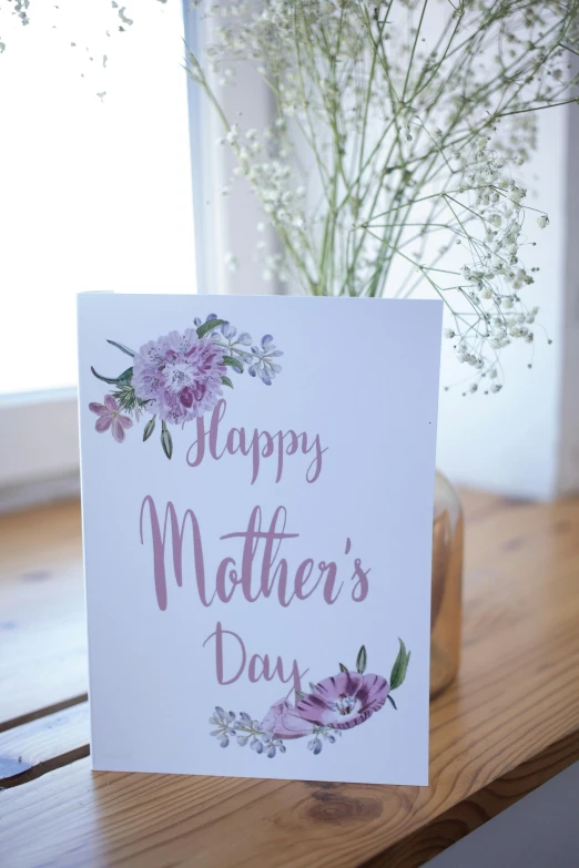 a mother's day card sitting on top of a wooden table, happening, white bg, floral motives, f / 4, happy mood