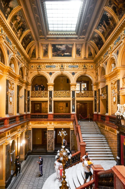 a couple of people that are standing in a building, inspired by Sydney Prior Hall, art nouveau, wide grand staircase, hull is a opera house, gilded with gold, historic artworks society