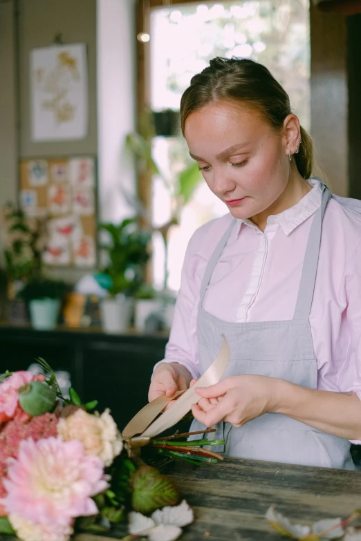 a woman is working in a flower shop, pexels contest winner, holding a kitchen knife, dasha taran, profile portrait, gif