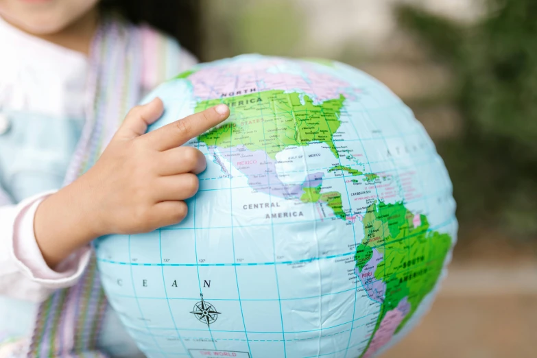 a little girl holding a globe in her hands, an album cover, by Julian Hatton, trending on unsplash, closeup - view, highly detailed map, inflateble shapes, educational supplies