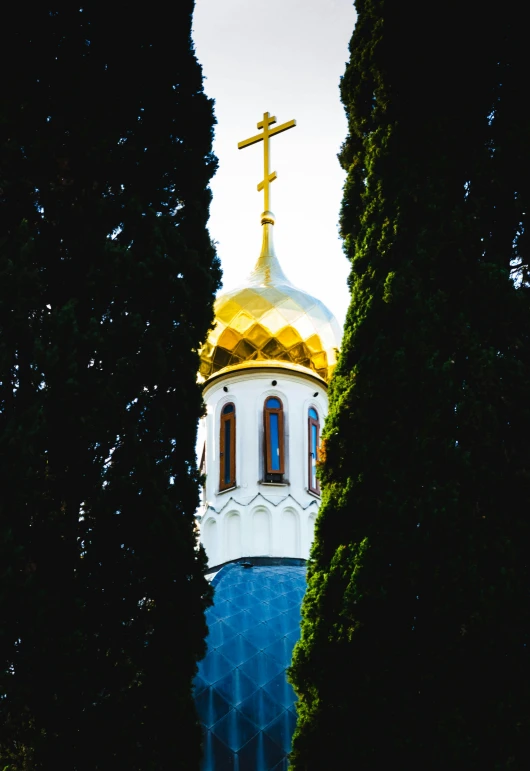 a tall building with a cross on top of it, an album cover, by Julia Pishtar, unsplash, baroque, russian temple, trees around, golden orbs, telephoto shot