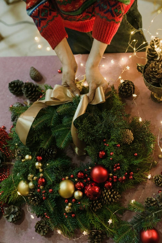 a dog sitting on top of a table next to a wreath, hands, with sparkling gems on top, blending, hanging