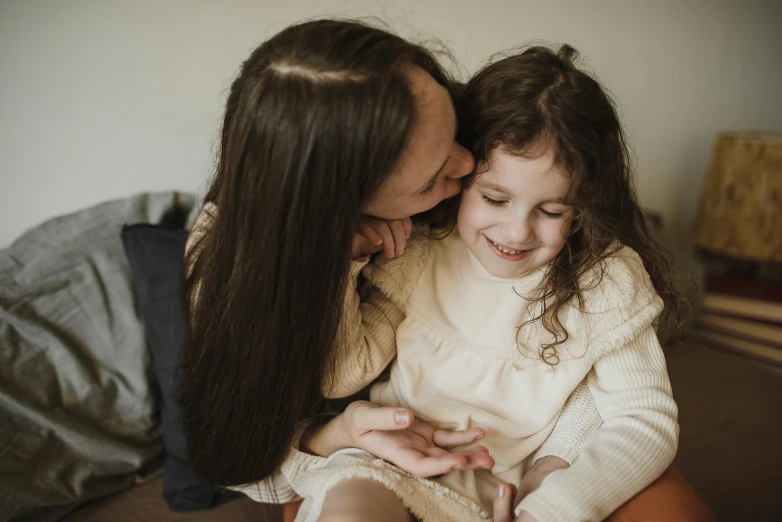 a woman sitting next to a little girl on a bed, pexels contest winner, holding each other, girl with dark brown hair, soft lulling tongue, 15081959 21121991 01012000 4k